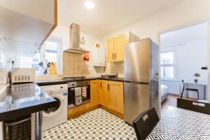 a kitchen with a stainless steel refrigerator and cabinets at Mile end Double rooms 86a in London