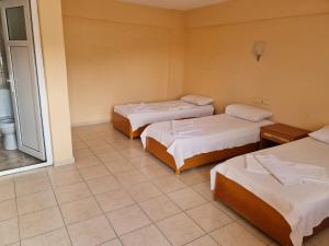 a room with three beds and a window at Caner Mountain Hotel in Antalya