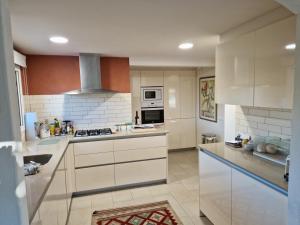 a kitchen with white cabinets and a stove top oven at Villa Casa Cis in Calella de Palafrugell