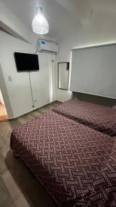 1 dormitorio con 1 cama en una habitación con TV en TRES CERRITOS SALTA en Salta