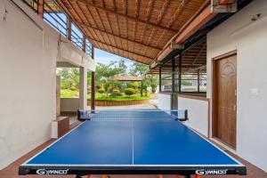 een grote blauwe tafeltennistafel in een huis bij Hatti Eden Coorg in Gonikoppal