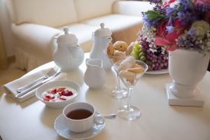 a white table with a cup of coffee and a cup of tea at Hotel De Londres in Rimini