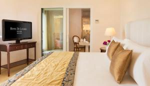 a bedroom with a bed with a television on a table at Hotel De Londres in Rimini