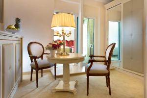 a dining room with a table with chairs and a lamp at Hotel De Londres in Rimini