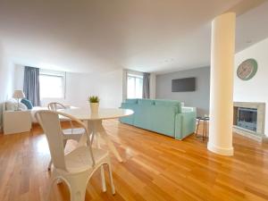 a living room with a table and a blue couch at Apartments City Center • Collection by Perpetual Relax in Braga +31 photos
