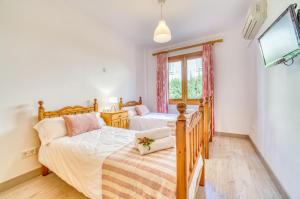 a bedroom with two twin beds and a tv at Pins 441 Derecha in Playa de Muro