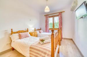 a bedroom with two twin beds and a tv at Ideal Property Mallorca - Avinguda dels Pins 441 in Playa de Muro