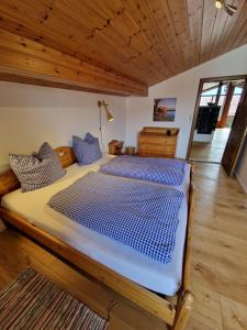 ein großes Bett in einem Zimmer mit Holzdecke in der Unterkunft Chalet Chiemgau 90 qm 3 Zimmer Balkon in Übersee