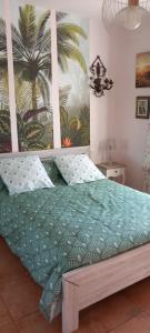 a bedroom with a bed with a palm tree mural at Belle villa entre la montagnette et les Alpilles in Tarascon