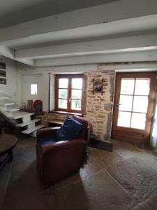 salon z kanapą i dwoma oknami w obiekcie Maison de famille en Bourgogne proche de Cluny w mieście Saint-Point