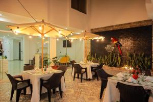 un restaurante con mesas y sillas y un loro en la pared en Hotel Boutique Papagayo, en Tarapoto