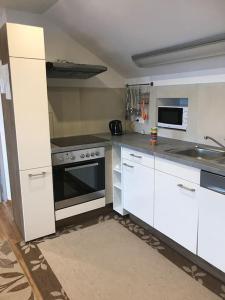 a kitchen with white cabinets and a stove top oven at Ferienwohnung in Wiesent-gerne Handwerker/Monteure in Wiesent