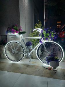 a white bike parked on a sidewalk with flowers at Apartments Aleksandra Cetinje in Cetinje