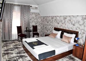Osiyo Hotel في سمرقند: غرفة نوم بسرير وطاولة وكراسي