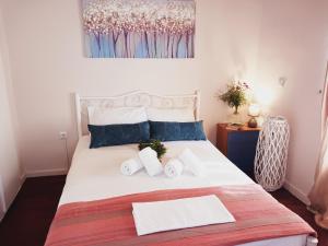 um quarto com uma cama branca e toalhas em Fairytale em Boïkátika
