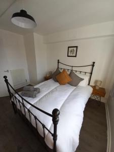 a bedroom with a large bed with white sheets at Derby City Apartment with free parking in Derby