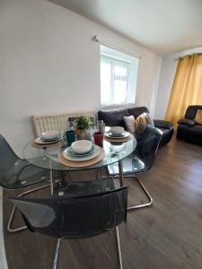 a glass table and chairs in a living room at Derby City Apartment with free parking in Derby