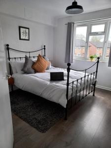 a bedroom with a bed with a laptop on it at Derby City Apartment with free parking in Derby