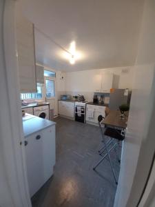 una cucina con armadi bianchi e un tavolo di Derby City Apartment with free parking a Derby Altre 5 foto