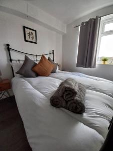 a white bed with a towel on top of it at Derby City Apartment with free parking in Derby