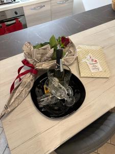 un piatto con una bottiglia di vino e bicchieri su un tavolo di Casa medievale Il Rifugio di Olimpia a Viterbo
