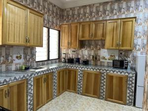 a kitchen with wooden cabinets and a white refrigerator at Executive 2 Bedrooms Apartment in Amuna