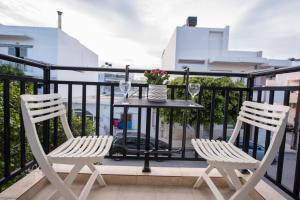 twee witte stoelen en een tafel op een balkon bij 4k GEM in Ierápetra