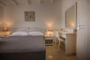 a bedroom with a bed and a desk and a table and chair at 4k GEM in Ierápetra