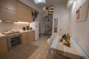a kitchen with a table and a white refrigerator at 4k GEM in Ierápetra