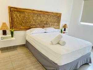 1 dormitorio con 1 cama grande y 2 toallas. en Las palmeras de bocapan, en Tumbes