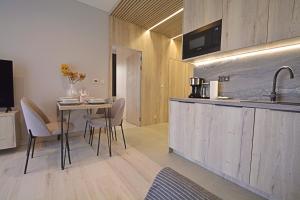 a kitchen and dining room with a table and a sink at Apartamenty Bryza-Baltycki - Apartamenty przy plaży z parkingiem in Świnoujście