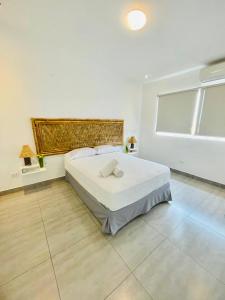 a bedroom with a large bed and a large window at Las palmeras de bocapan in Tumbes