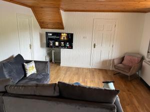 a living room with a couch and a chair at Large Newly Refurbished Lakeside Chalet With Optional Hot Tub & Boat Hire in Duneena