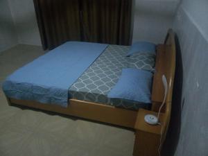 a bed with a wooden frame in a room at Executive 2 Bedrooms Apartment in Amuna
