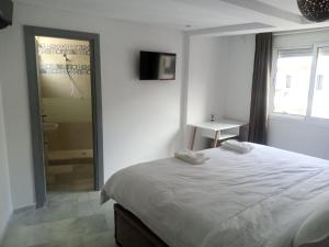 a bedroom with a bed and a bathroom with a shower at Nouvel appartement climatisé in Fez