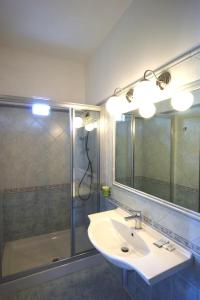 a bathroom with a sink and a shower and a mirror at Hotel Liberty in Viareggio