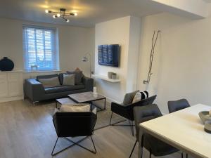 a living room with a couch and a table and chairs at Lux Cottage Conwy in Conwy