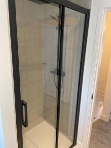 a glass shower in a room with a door at Lux Cottage Conwy in Conwy +4 photos