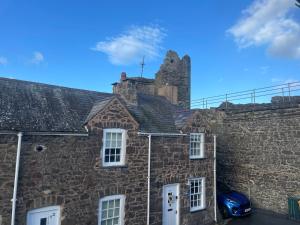 un viejo edificio de piedra con una chimenea encima en Lux Cottage Conwy en Conwy