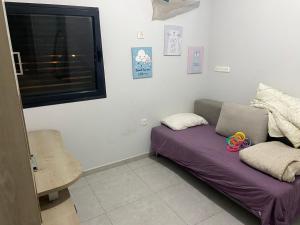 un sofá en una habitación con ventana en Beauty apartment 3 rooms wi-fi, en Netanya