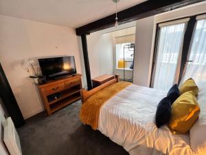 a bedroom with a bed and a flat screen tv at Stunning Liverpool City Center Apartment in Liverpool