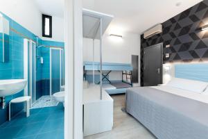 een slaapkamer met een bed en een badkamer bij Hotel Eiffel in Rimini