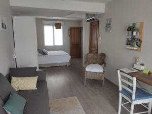 una pequeña sala de estar con cama y escritorio en L'Ansolanette - Chambre d'hôtes en Fuveau