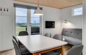 comedor con mesa blanca y sillas en Amazing Apartment In Vggerlse With Kitchenette en Bøtø By