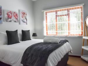 a bedroom with a large white bed and a window at De Hoek Selfsorg Eenhede in Beaufort West