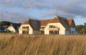 a large white house with a brown roof at Fewo 41 Putbus-rgen in Wreechen