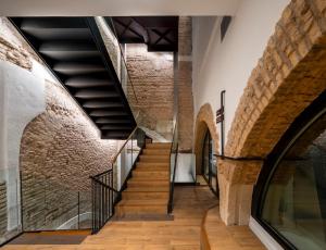eine Treppe in einem Gebäude mit Ziegelwänden in der Unterkunft nQn Aparts & Suites Sevilla in Sevilla