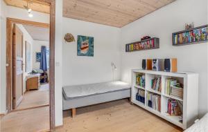 1 dormitorio con 1 cama y estantería con libros en Awesome Home In Kirke Hyllinge With House Sea View, en Kirke-Hyllinge
