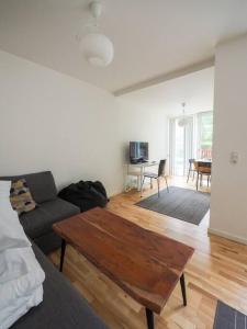 ein Wohnzimmer mit einem Sofa und einem Tisch in der Unterkunft Simple & cosy flat -2 minutes to Nuuks Plads metro in Kopenhagen