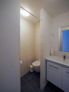 a white bathroom with a toilet and a sink at Simple & cosy flat -2 minutes to Nuuks Plads metro in Copenhagen